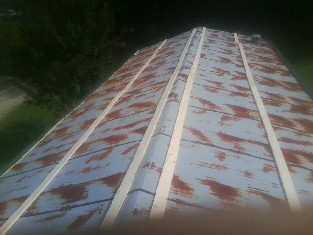 Rusted metal roof panels with new wood purlins before replacement — Storm Damage Roof Repair in Mount Victory by Roofing Brothers